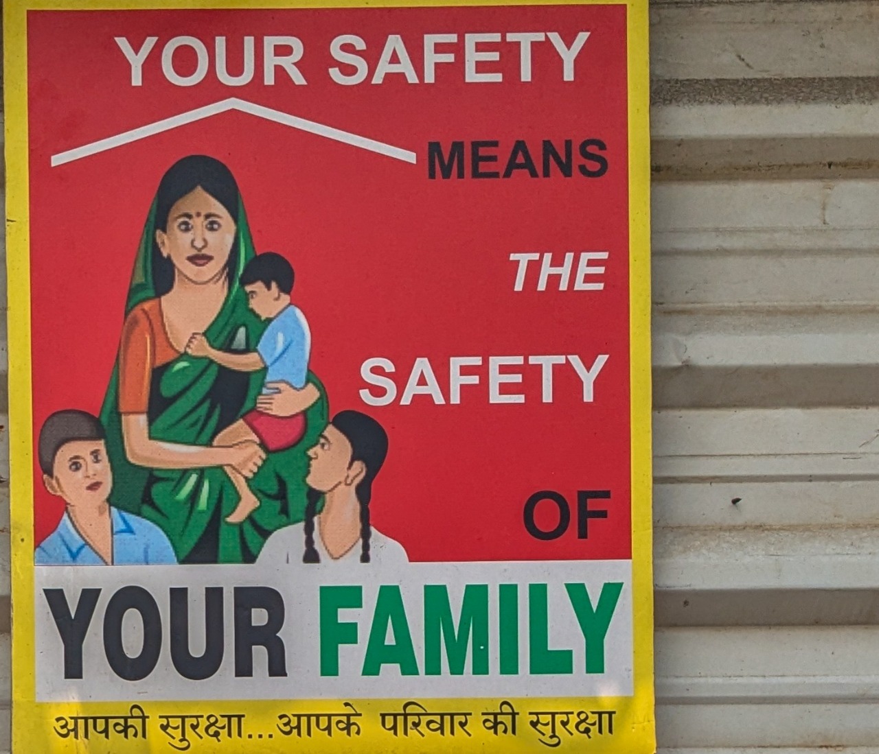 A poster that reads "Your safety means the safety of your family" in Hindi and English