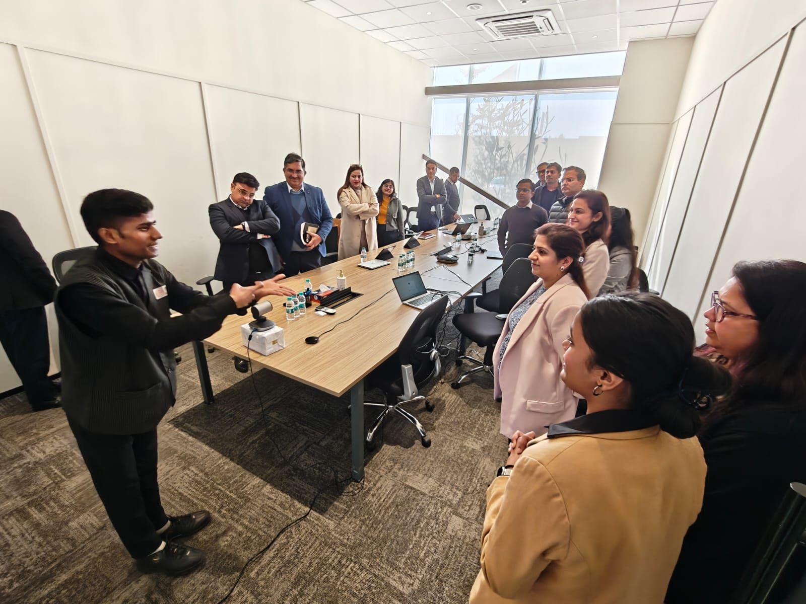 Photograph of a meeting room full of people in conversation.